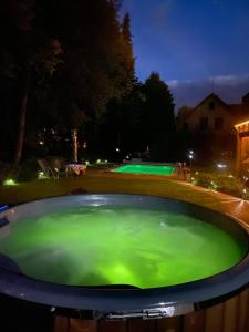 una piscina de agua verde en un patio por la noche en Droom b&b Čermná, en Čermná