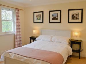 Haugh House في أبرلور: غرفة نوم مع سرير مع مواقف ليلتين ومصباحين