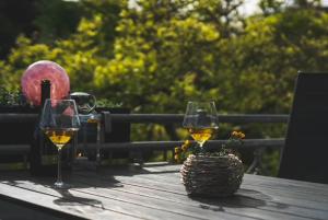 two glasses of wine and a basket on a wooden table at Ferienwohnung Brossmann in Eltville