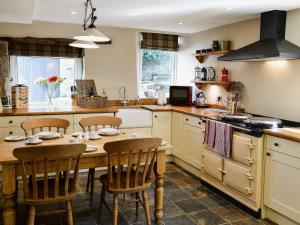 a kitchen with a wooden table and chairs in it at High Houses in Wath