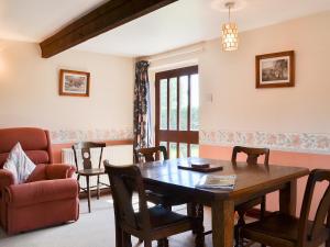a dining room with a table and a chair at The Cider Mill Cottage in Orleton