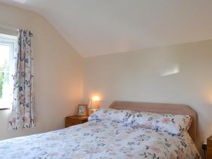 a bedroom with a bed and a window at The Cider Mill Cottage in Orleton