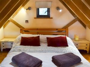 a bedroom with a bed with two pillows on it at The Cowstall in Framfield