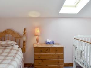 a bedroom with a bed and a lamp on a dresser at Little Barn - 16438 in Huntington