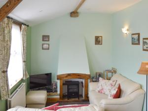a living room with a white couch and a tv at Coble - 16262 in Staithes