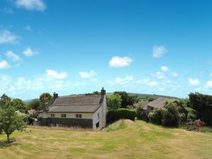 a house on a hill with a grassy field at Boundstone Farmhouse in Littleham