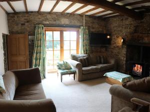 a living room with a couch and a fireplace at Boundstone Farmhouse in Littleham