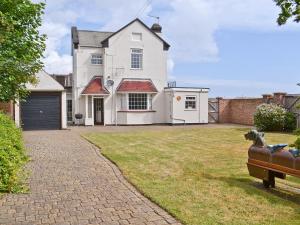 a house with a dog sitting on a couch in the yard at Dune Cottage in Caister-on-Sea