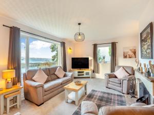 a living room with two couches and a fireplace at West Home in Torridon