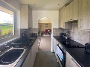 uma cozinha com um lavatório e uma grande janela em Eden - B6526 em Saint Cleer
