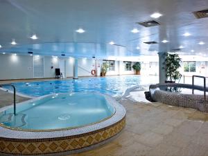 una gran piscina con bañera de hidromasaje en un edificio en Clematis, en Saint Wenn