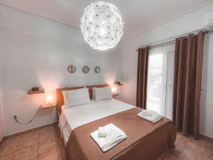 a bedroom with a large bed and a chandelier at Filanthis inn in Kalamata