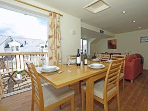 a dining room with a table and chairs and a balcony at Watermark in Saint Columb Minor