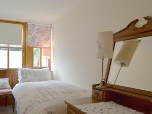a bedroom with two beds and a mirror at Temple House West in Drumnadrochit