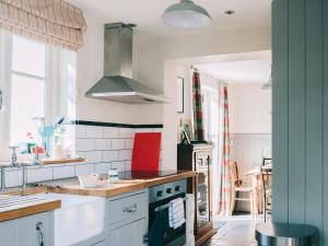 a kitchen with a sink and a stove top oven at Southfield Cottage in Braunston