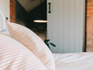 un primer plano de una cama con una almohada a rayas en Southfield Cottage en Braunston