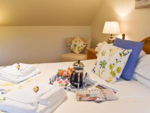 a bed with a pile of towels on it at Carron View in Strathcarron