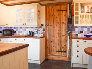 a kitchen with white cabinets and a wooden door at The Old Bakery in Wendover