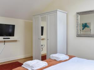 a bedroom with a white closet with two towels at Oak Tree Cottage in Otterburn