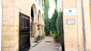 alejka z czarną bramą w budynku z roślinami w obiekcie Vivienda Turística Cervantes w mieście Úbeda