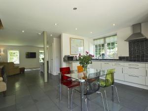 a kitchen and dining room with a glass table and chairs at Curlew Barn in Sutton Bridge