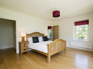 a bedroom with a bed and two windows at Curlew Barn in Sutton Bridge