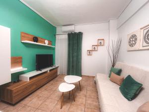 a living room with a couch and a tv at Filanthis inn in Kalamata
