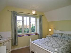 a bedroom with a bed and a sink and a window at Moorhouse Farm Cottage in Hovingham