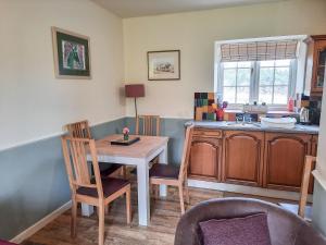 a kitchen with a table and chairs and a sink at Moorhouse Farm Cottage in Hovingham