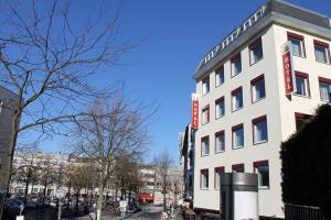 a white building with a sign on the side of it at Apartment Hotel am Sand 24H Self Check-in in Hamburg