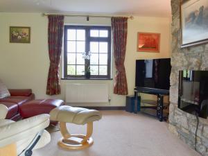 a living room with a couch and a tv at Tripp Cottage in Saint Neot