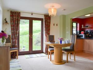 a kitchen and living room with a table and chairs at Tripp Cottage in Saint Neot
