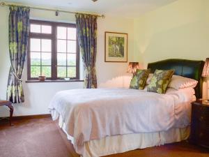 a bedroom with a bed and a window at Tripp Cottage in Saint Neot