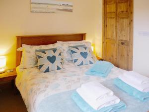 a bedroom with a bed with towels on it at Hawthorn in Hartland