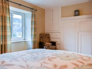 CastletownにあるPebblesのベッドルーム1室(ベッド1台、椅子、窓付)