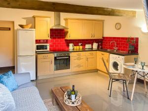a kitchen with a couch and a table in a room at Bluebell Cottage - 27635 in Darenth