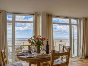 a dining room with a table with a view of the beach at Seaspray in Camber