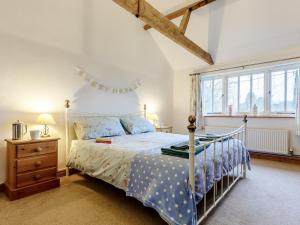 a bedroom with a bed and a window at Wheelwrights Cottage in Rumburgh