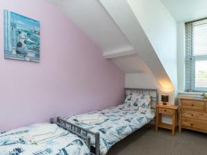 a bedroom with two beds and a dresser at Porto Seguro in Brixham