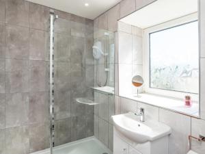 a bathroom with a shower and a sink and a mirror at Porto Seguro in Brixham