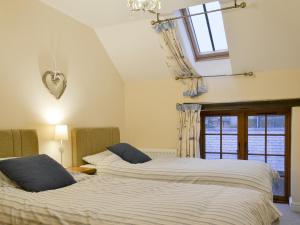 a bedroom with two beds and a window at Tawny Owl -27819 in Westleigh