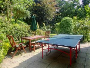 a ping pong table with two chairs and an umbrella at Heale Cottage - 28087 in Littleham