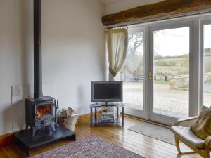 North Willingham的住宿－布賴德爾斯鄉村別墅，客厅设有壁炉和电视。
