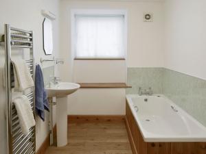 a bathroom with a sink and a tub and a window at The Bridles -26718 in North Willingham