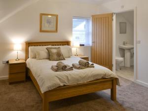 - une chambre avec un lit et 2 serviettes dans l'établissement Abbey Cottage, à Longhirst