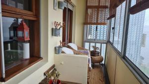 einen Balkon mit Fenstern und einem Stuhl in einem Zimmer in der Unterkunft Apartamento vista Douro e Mar in Porto