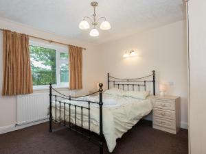 a bedroom with a black bed and a window at Oaklands in Langrigg