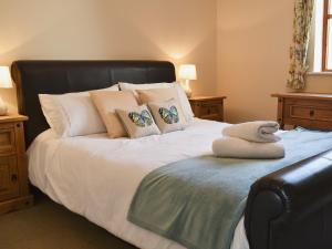 a bedroom with a bed with a black headboard and pillows at Church View in Crackington Haven