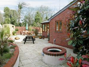 a backyard with a brick house and a patio at Church View in Crackington Haven