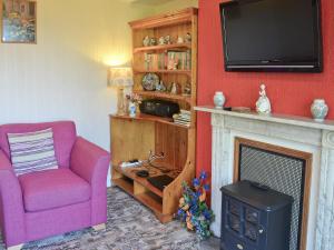a living room with a chair and a fireplace at Suffolk House Annexe in Harrow on the Hill